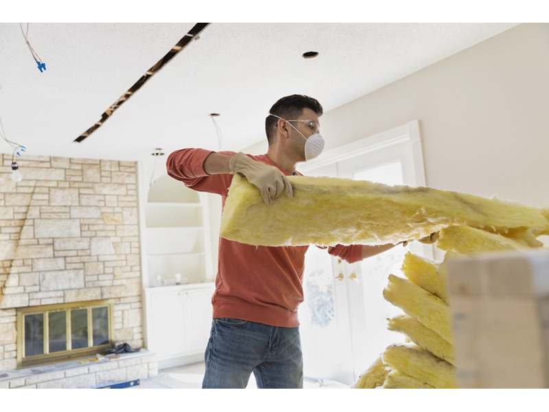 Mindent a belső szigetelésről az Építőanyag pont hu oldalon Férfi belső szigeteléshez üveggyapot szigetelőanyagot készít elő védőfelszerelésben, hesztyűben, maszkban és védőszemüvegben a lakásban