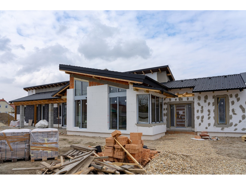 őszi homlokzati hőszigetelés előnyei hátrányai A fotón egy felépült, de még nem vakolt ház látható ami őszi homlokzati hőszigetelésen esett át korszerű szigetelőanyagokkal